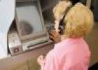 Mujer mayor con cascos usando un ordeandor