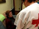 Una mujer es atendida por una voluntaria de Cruz Roja