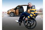 Discapacitado en silla de ruedas frente a un vehículo