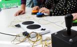 Varias personas utilizan el mando adaptado de Xbox mediante pulsadores.