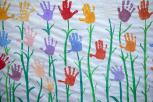 Lienzo con estampación de manos de niños a modo de flores.