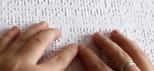 Manos leyendo en Braille.