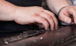 Una persona utiliza una línea braille en su ordenador.