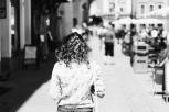 Mujer de espalda paseando por una calle.