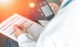 Un doctor utiliza su teléfono móvil para el seguimiento de un paciente.