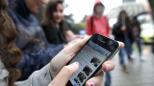 Jóvenes en la calle, una usando Whatsapp