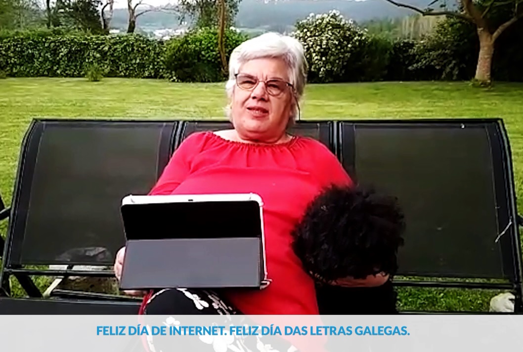 Fotograma del vídeo, con una mujer mayor usando una tablet en su jardín.