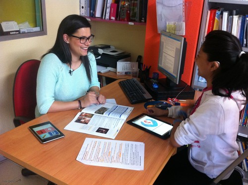 Una profesora prueba la aplicación con una niña con audífono.